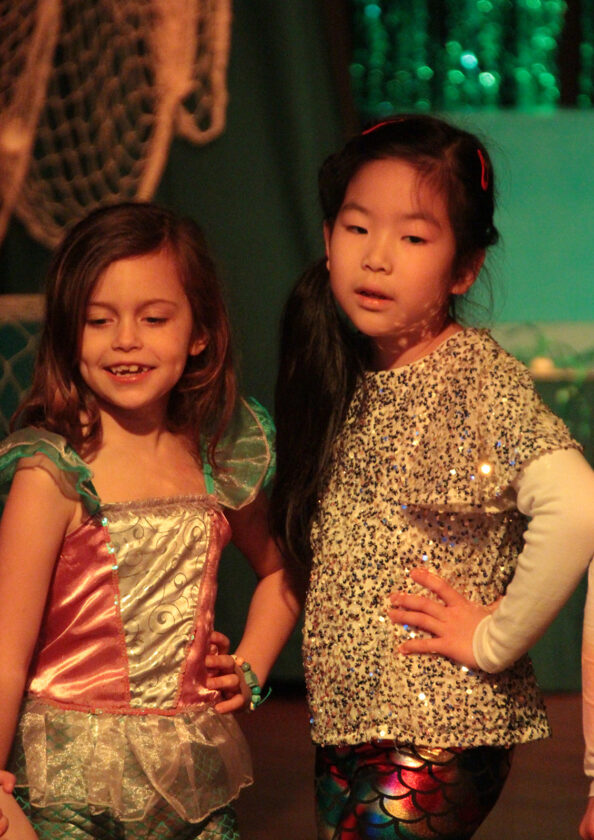 Year 3 girls dressed as mermaids during performance of 'Pirates Versus Mermaids'.
