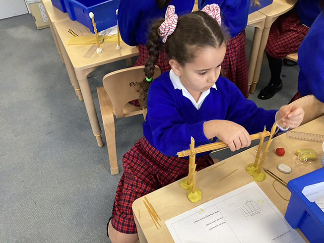 Year 2 girl building a bridge out of pasta and playdough.