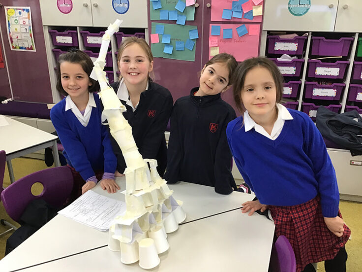 Year 3 girls building towers out of index cards, paper cups and masking tape.