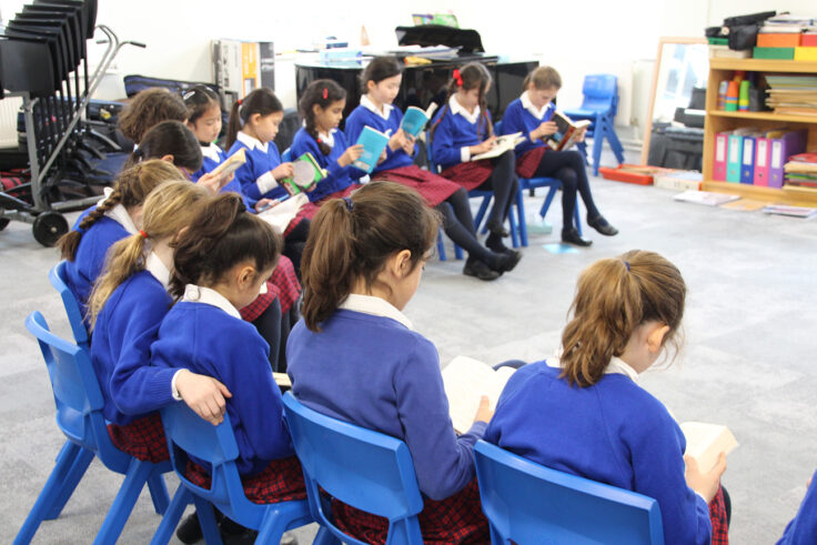 Ken Prep girls reading during their music lesson.
