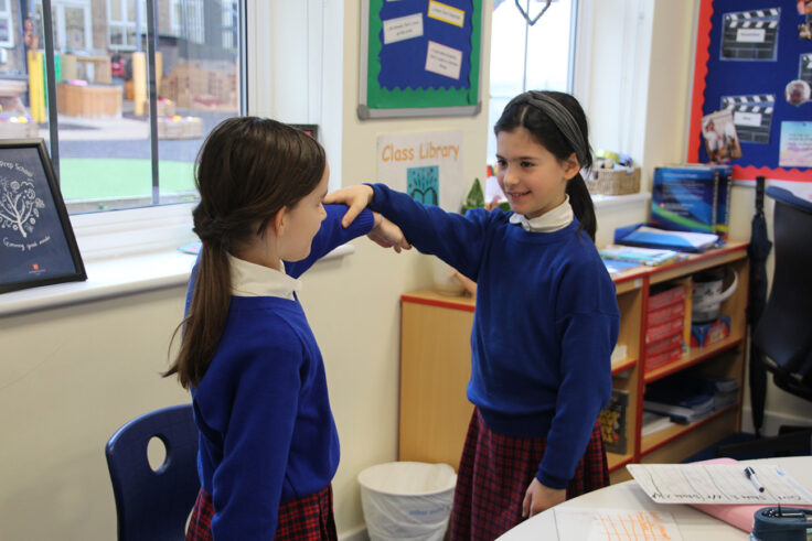 Year 5 holding each other's arms as part of a science experiment.